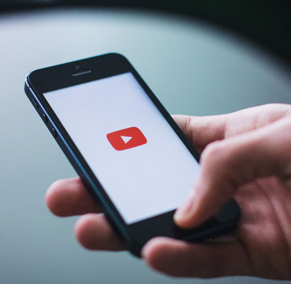 person holding a phone, accessing YouTube