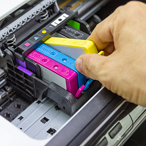 a person inserting toner into a printer